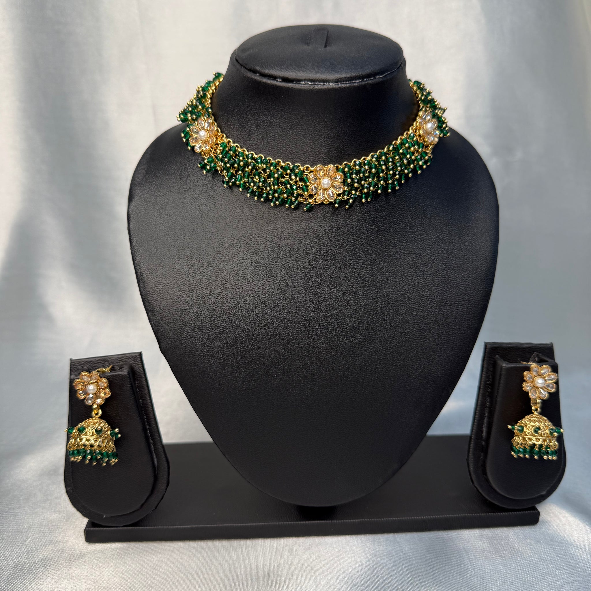 Jewelry set with necklace and earrings on a black mannequin bust against a white background