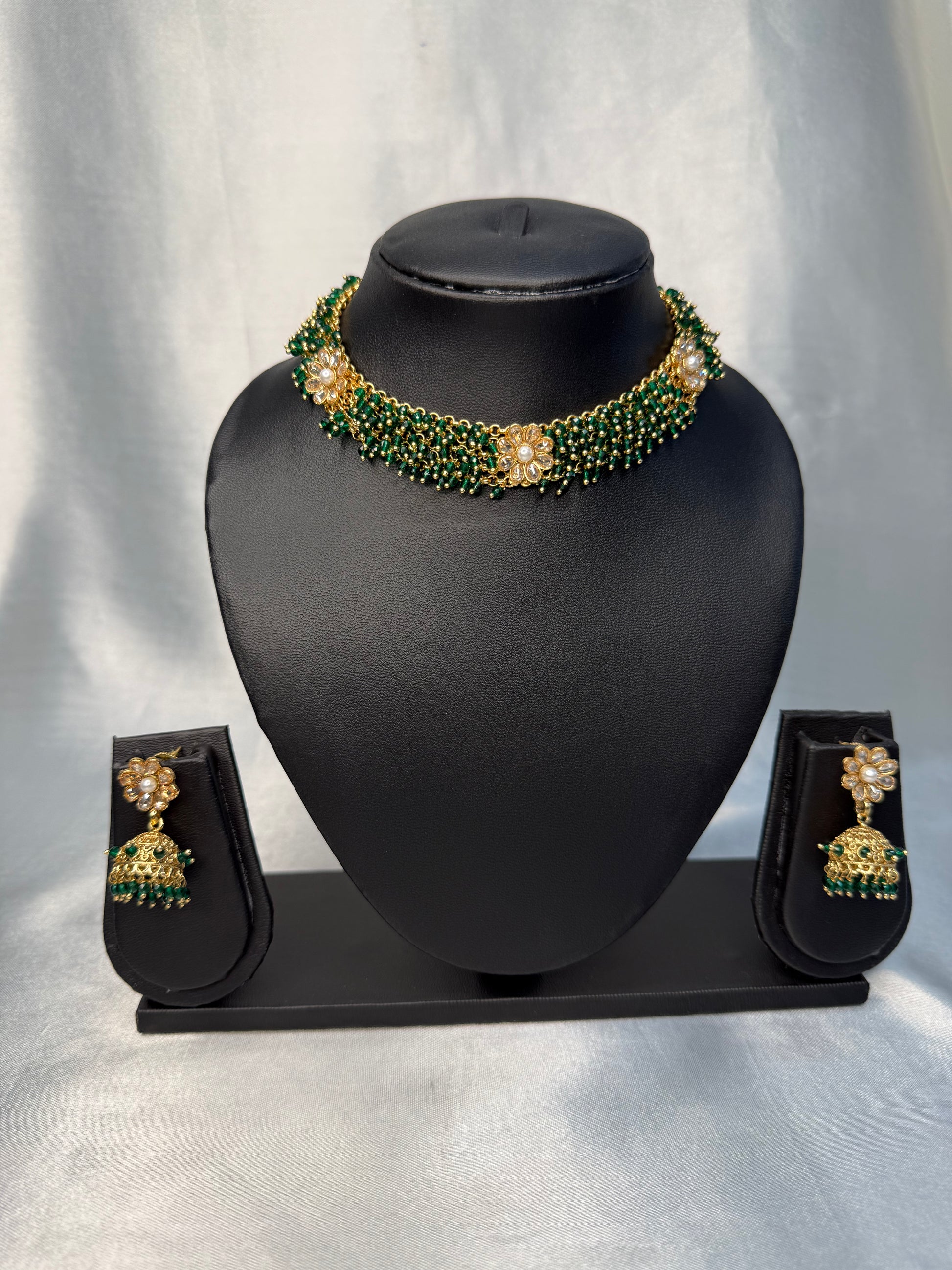 Jewelry set with necklace and earrings on a black mannequin bust against a white background