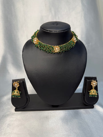 Jewelry set with necklace and earrings on a black mannequin bust against a white background