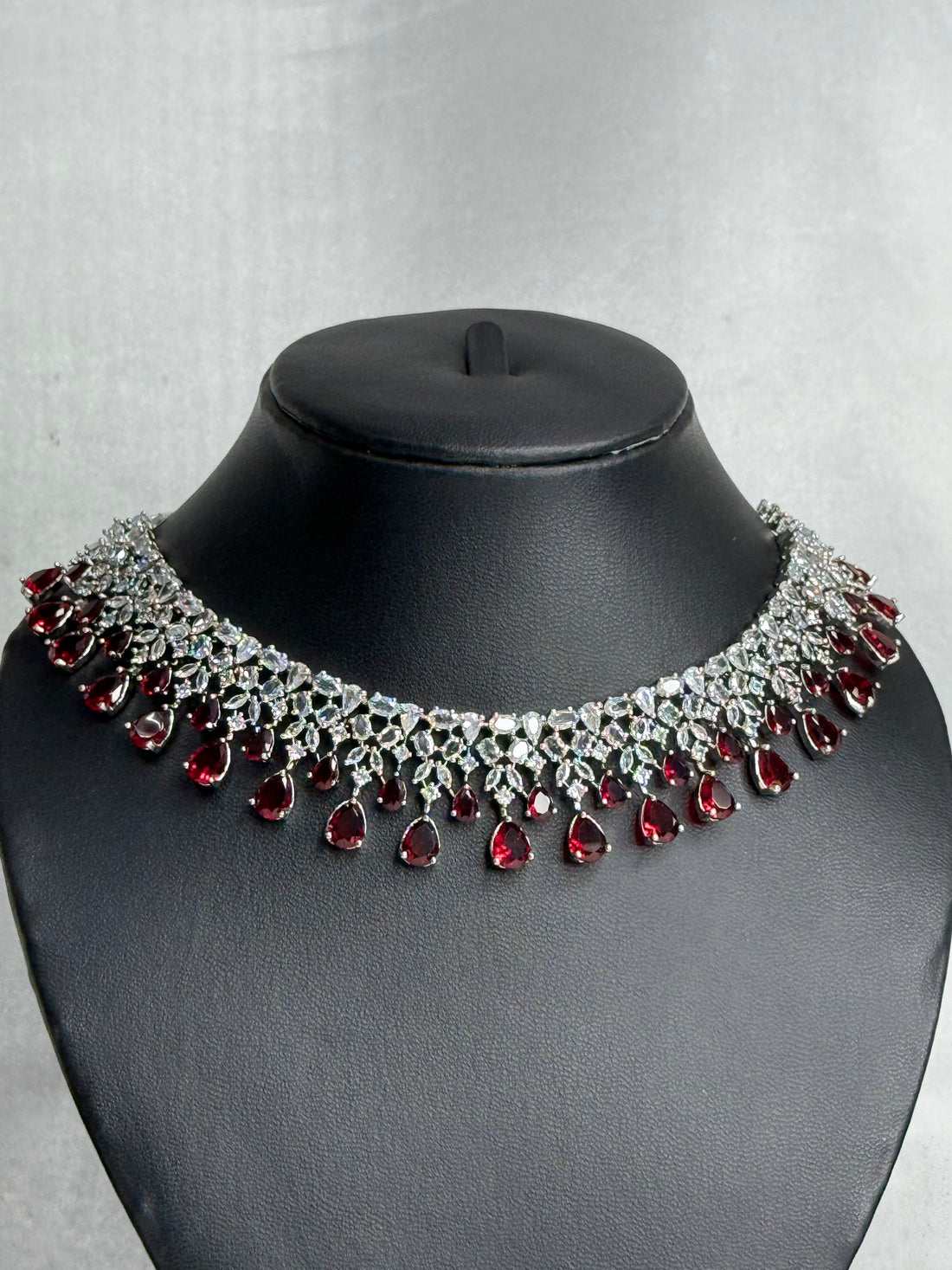 Jewelry set with necklace, earrings, and box on a gray background