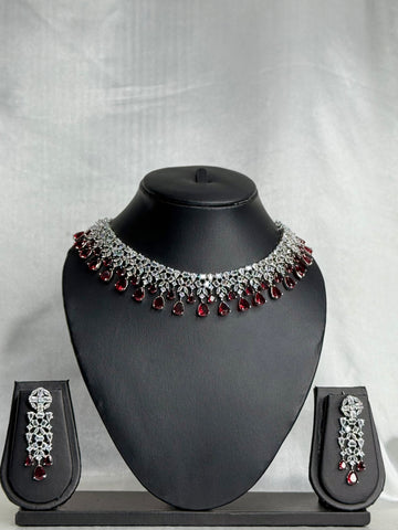 Jewelry set with necklace, earrings, and box on a gray background