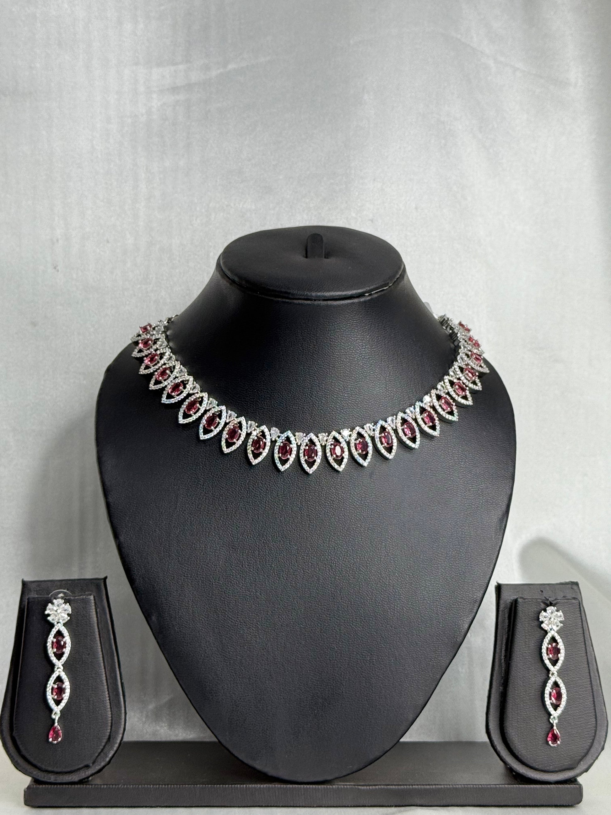 Jewelry set with necklace and earrings on a black mannequin bust against a gray background