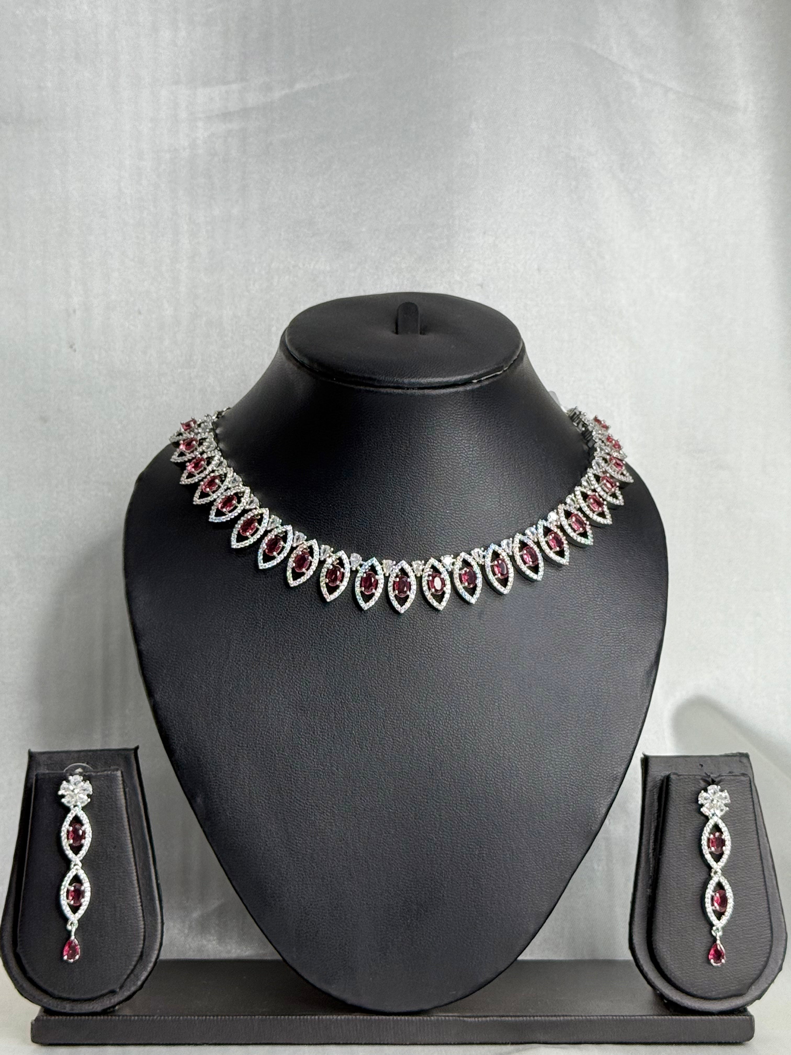 Jewelry set with necklace and earrings on a black mannequin bust against a gray background