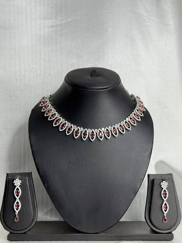 Jewelry set with necklace and earrings on a black mannequin bust against a gray background