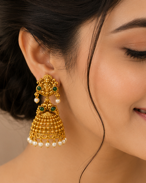 Antique gold Goddess Lakshmi emerald cabochon grand granule bead dome jhumka earrings with pearl drop connector and seed pearl drops on cream marble display