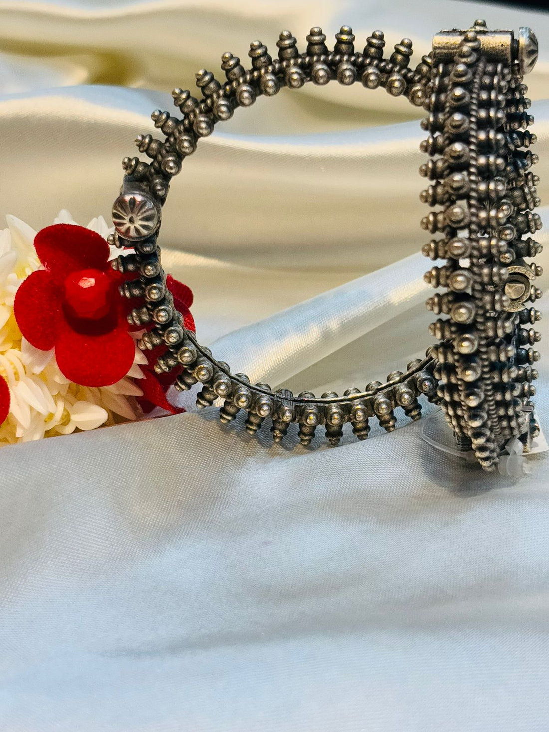 Decorative metal object with beads on a light background