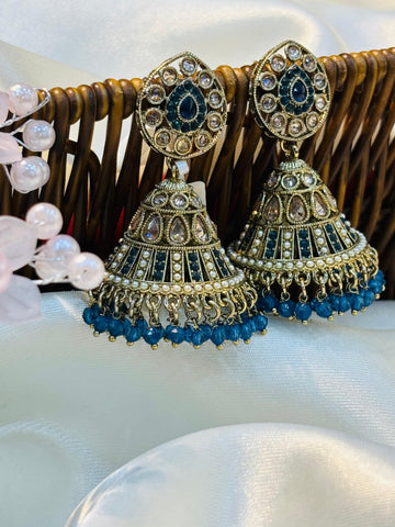 Ornate earrings with blue beads on a white surface