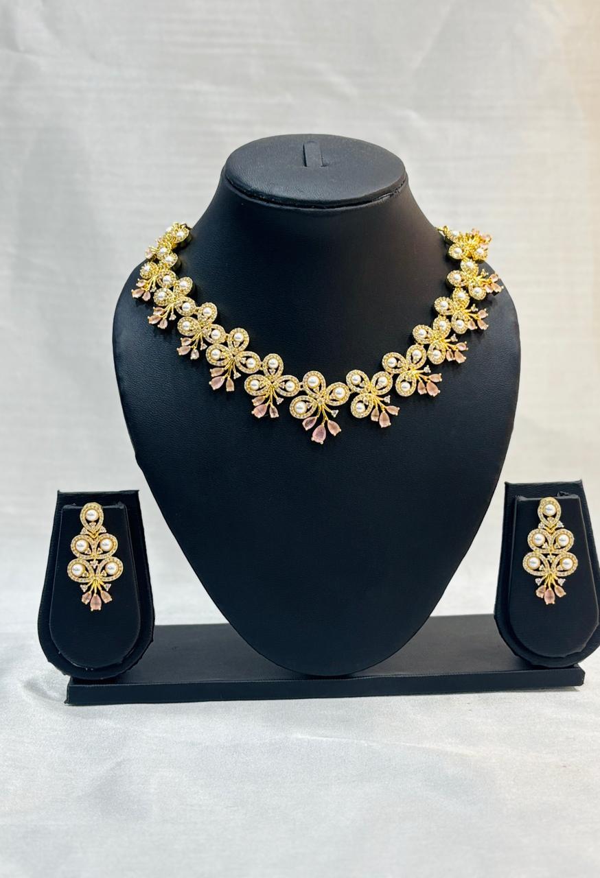 Gold necklace and earrings set on a black mannequin bust with a white background