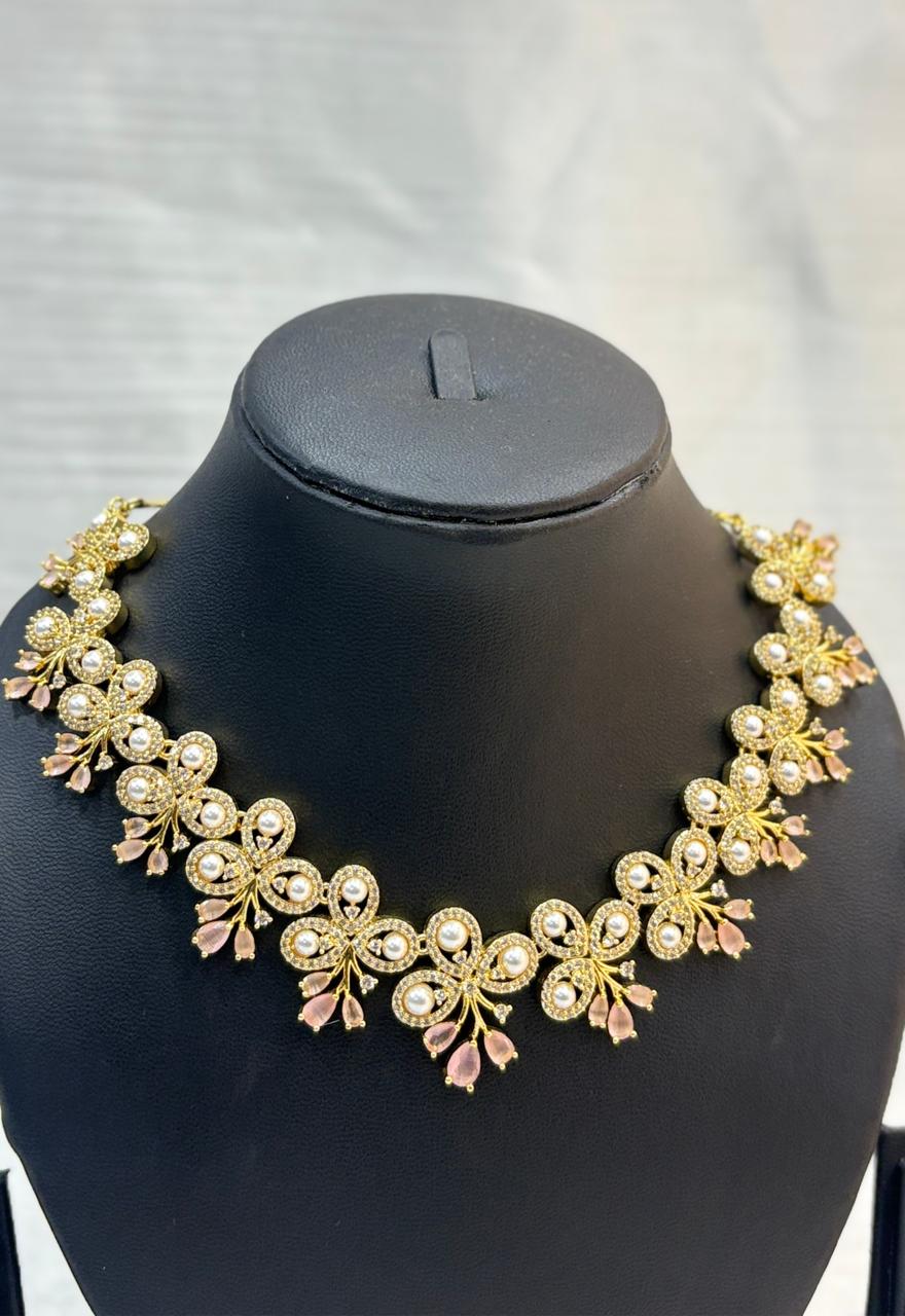 Gold necklace and earrings set on a black mannequin bust with a white background