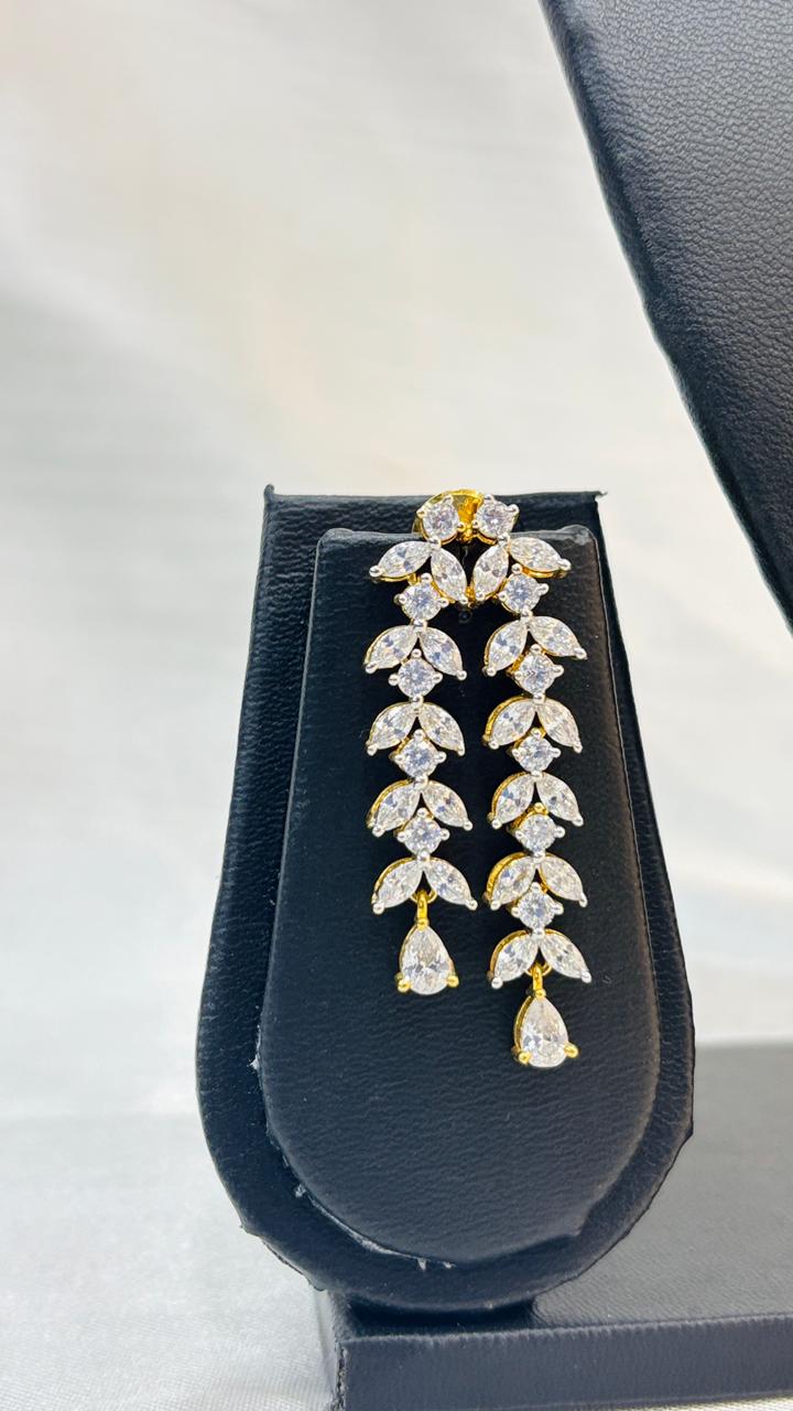 Pair of diamond earrings in a black jewelry box on a light gray background