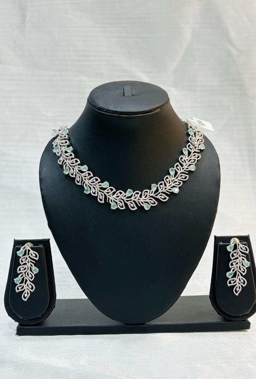 Jewelry set with necklace and earrings on a black mannequin bust against a white background