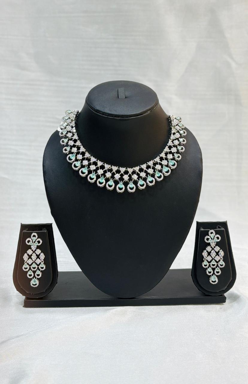 Jewelry set with necklace and earrings on a black stand against a white background