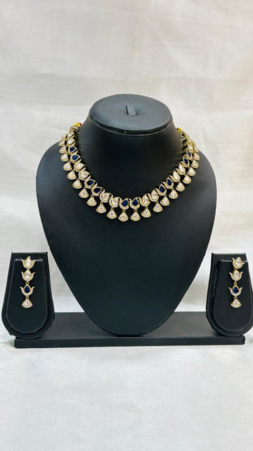 Gold necklace with matching earrings on a black mannequin bust against a white background