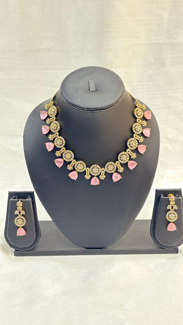 Jewelry set with necklace and earrings on a gray stand against a light background