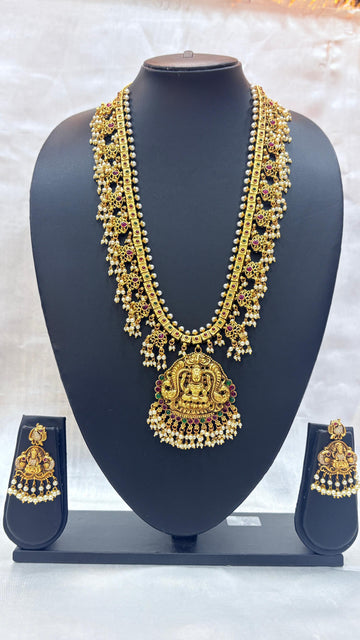 Gold necklace and earrings set on a black mannequin against a white background